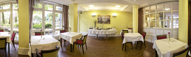 Panoramabild: Der Fr�hst�cksraum! So l�sst sich der Tag starten. In gem�tlicher Umgebung f�llt der Start in den Tag nicht schwer. Um das leckere B�fett sind einzelnen Tische angeordnet.